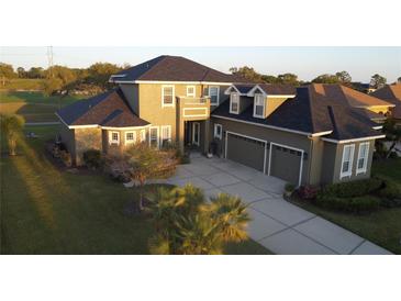 Beautiful home featuring an attached three-car garage and a well-manicured lawn at 7330 Reflections Lake Dr, Lakeland, FL 33813