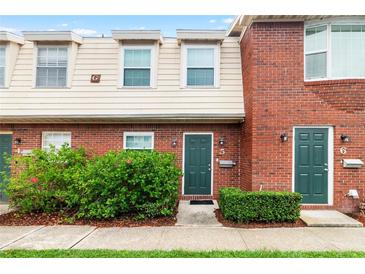Brick townhouse exterior with green door, landscaping, and walkway at 1920 E Edgewood Dr # G5, Lakeland, FL 33803