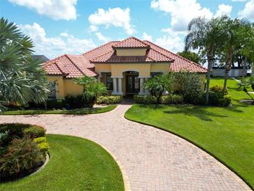 Stunning home boasts a curved brick driveway, lush landscaping, and a vibrant terracotta roof at 341 Hamilton Shores Dr. Ne, Winter Haven, FL 33881