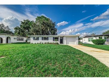 Charming single-story home with a well-manicured lawn and attached garage, set against a bright blue sky at 2350 E Washington St, Bartow, FL 33830