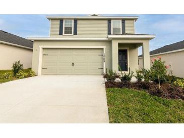 Charming two-story home with attached two-car garage, neat landscaping, and a welcoming front entrance at 1009 Mountain Flower Ln, Davenport, FL 33837