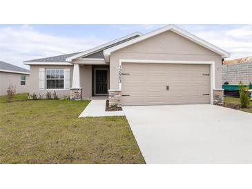 Charming one-story home featuring a wide driveway and a two-car garage at 12863 Se 53Rd Ct, Belleview, FL 34420