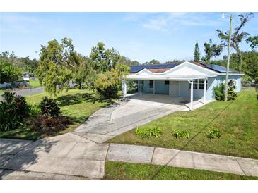 Charming single-story home featuring a covered carport and well-maintained landscaping with solar panels at 1220 Woodland Ave, Lakeland, FL 33801