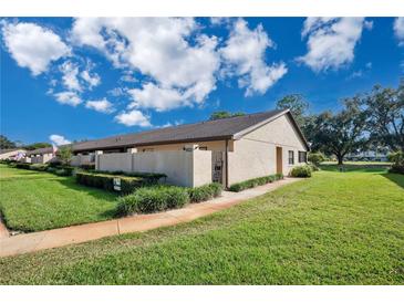 Charming villa featuring lush landscaping, private courtyard, and covered front entry at 2256 Firestone Pl, Winter Haven, FL 33884