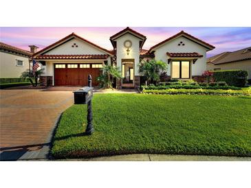 Charming two-story home with a well-manicured lawn, mailbox, and driveway leading to a two-car garage at 3000 Sanctuary Cir, Lakeland, FL 33803