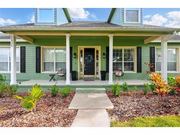 Inviting home featuring a covered front porch with decorative columns and well-manicured landscaping at 1935 Austin Ter, Winter Haven, FL 33884