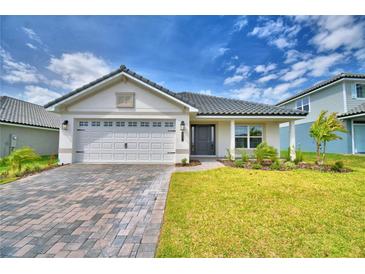 Charming single-story home with a two-car garage, lush lawn, and inviting front entrance at 4700 Grandview Glen Dr, Auburndale, FL 33823