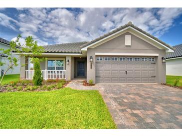 Charming single-story home featuring a paved driveway, manicured lawn, and covered porch entry at 4706 Grandview Glen Dr, Auburndale, FL 33823