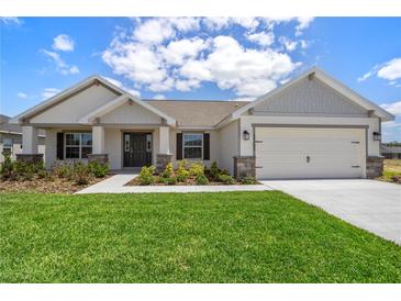 Charming single-Gathering home featuring a well-manicured lawn and a two-car garage at 1365 Melrose St, Lake Alfred, FL 33850