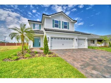 Beautiful two-story home boasts a three-car garage, manicured lawn, vibrant landscaping, and modern design at 4712 Grandview Glen Dr, Auburndale, FL 33823