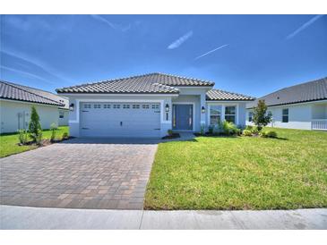 Beautiful single-story home featuring a stone driveway, gray siding, and a well-manicured lawn at 4639 Grandview Glen Dr, Auburndale, FL 33823