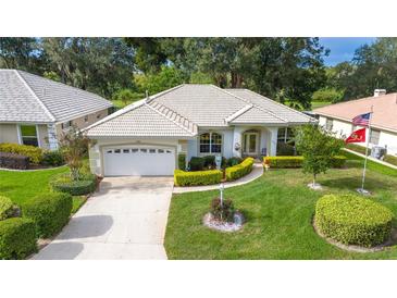 Single-story home with tile roof, landscaped yard, and a two-car garage at 202 Golf Aire Blvd, Winter Haven, FL 33884