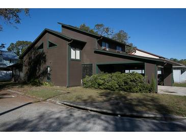 Two-story home with brown siding, green trim, and well-kept front yard at 3597 Raintree Ln, Lakeland, FL 33803