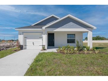 Charming single-Gathering home featuring a tidy lawn, a single-car garage, and a welcoming front porch at 428 Ituna Cir, Winter Haven, FL 33881