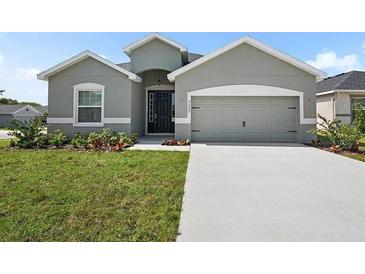 Charming single-story home with a well-manicured lawn, inviting entrance, and attached two-car garage at 723 Bentley North Loop, Auburndale, FL 33823