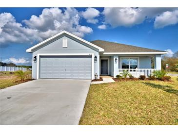 Charming single-story home with a gray exterior, a two-car garage, and a well-manicured front lawn at 4036 Tullamore Ln, Auburndale, FL 33823