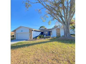 Charming single-story home featuring a well-maintained lawn, stone accents, and an attached garage at 3709 Feather Dr, Lakeland, FL 33812
