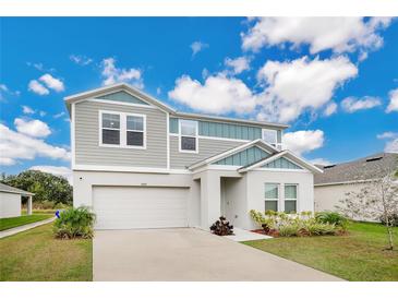 Two-story house with gray siding, two-car garage, and landscaped yard at 5460 Siltstone St, Lakeland, FL 33811