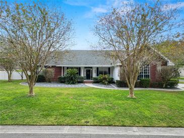 Brick house with a landscaped lawn and walkway at 1520 Royal Forest Loop, Lakeland, FL 33811