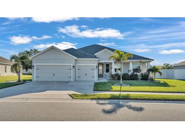 One-story home with two-car garage, palm trees, and manicured lawn at 241 Walkers Point Dr, Auburndale, FL 33823