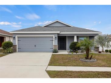 Gray house with two-car garage and landscaped front yard at 416 Monticelli Dr, Haines City, FL 33844