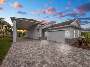 Single-story home with attached garage and paver driveway at 234 Laynewade Rd, Polk City, FL 33868