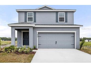 Charming two-story home with gray siding and a two-car garage, showcasing modern curb appeal at 447 Ituna Cir, Winter Haven, FL 33881