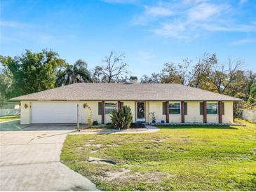 Single-story house with attached garage, brick accents, and a well-maintained lawn at 7101 Scenic Pl, Lakeland, FL 33810