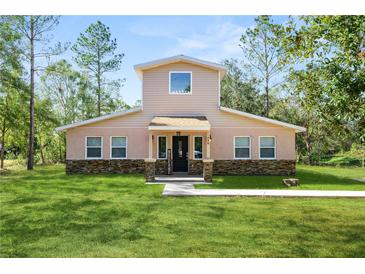 Two-story house with stone accents and a landscaped lawn at 748 Mcclellan Rd, Frostproof, FL 33843