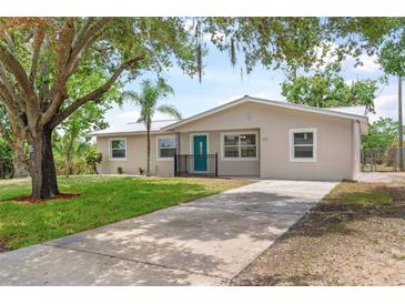 Newly renovated house with a teal front door and a spacious driveway at 107 W 7Th St, Frostproof, FL 33843