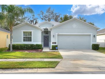 Single-story house with gray siding, two-car garage, and landscaped lawn at 3710 Madbury Cir, Lakeland, FL 33810