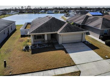 Charming single-story home with a well-manicured lawn and an attached two-car garage by the waterfront at 4018 Sundance Place Loop, Mulberry, FL 33860