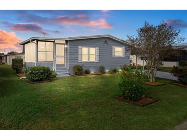 Nice, well-maintained manufactured home with a screened porch and landscaped lawn at 5079 Lodgewood Dr, Lakeland, FL 33810
