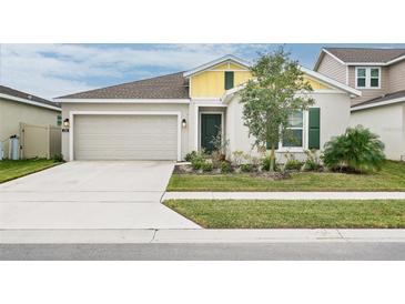House exterior featuring a two-car garage and well-maintained lawn at 636 Trotters Dr, Eagle Lake, FL 33839