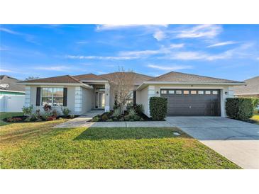 Charming single-story home with a well-manicured lawn, updated two car garage, and tidy landscaping at 1570 Doves View Cir, Auburndale, FL 33823
