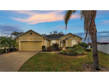 Beautiful yellow house with a landscaped yard and attached garage at 7406 Summit Pl, Lakeland, FL 33810