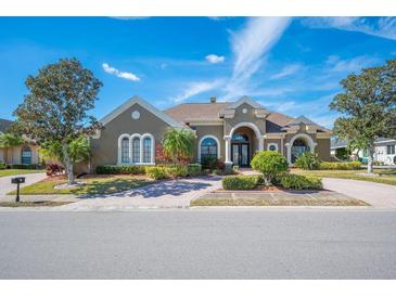 Beautiful 2-story house with a lush front yard, paver driveway and mature trees at 1217 Vista Hills Dr, Lakeland, FL 33813