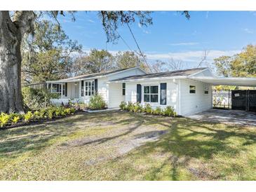 White house with carport, landscaping, and a spacious yard at 1317 W Belmar St, Lakeland, FL 33815