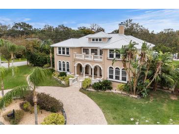 Two-story house with a metal roof, stone driveway, and lush landscaping at 1665 Blue Heron Ln, Lakeland, FL 33813