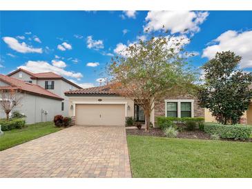 One-story home with stone accents, a paved driveway, and landscaped lawn at 1832 Prima Vista Dr, Lakeland, FL 33810