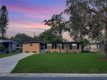 Updated ranch home with a landscaped lawn and a long driveway at 1914 Alexander Dr, Lakeland, FL 33803