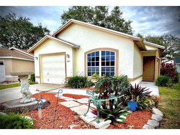 Cute one-story house with landscaped yard, inviting front porch, and attached garage at 2141 Sandy Hook, Lakeland, FL 33813