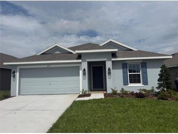 Charming single-story home with a two-car garage, blue shutters, and well-maintained landscaping at 237 Piave St, Haines City, FL 33844