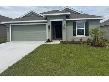 Charming one-story home with a well-manicured lawn, tidy landscaping, and a two-car garage at 245 Piave St, Haines City, FL 33844