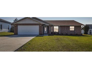 Brick house with a two-car garage and a well-maintained lawn at 3220 Cherry Hill S Cir, Lakeland, FL 33810