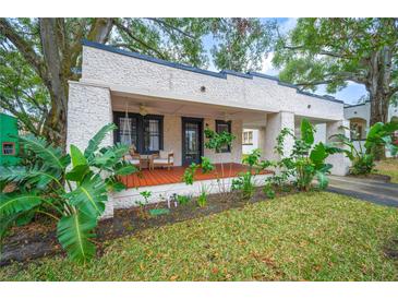 Inviting front porch with wooden decking, ceiling fan, and lush landscaping at 401 E Belmar St, Lakeland, FL 33803