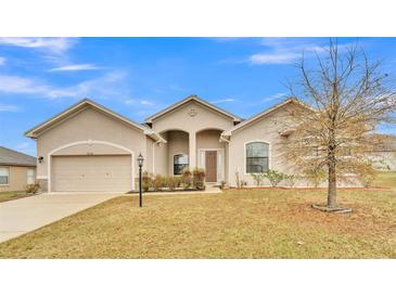 Tan one-story house with a two-car garage and landscaped lawn at 4236 Dinner Lake St, Lake Wales, FL 33859