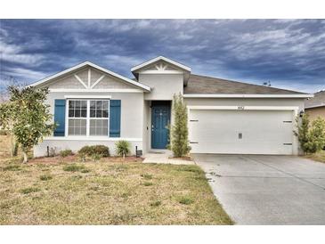 One-story home with gray siding, blue shutters, and a two-car garage at 442 Jacks Way, Davenport, FL 33837