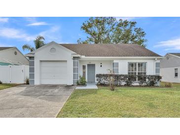 White one-story house with gray accents, attached garage, and well-maintained lawn at 6111 Morningview Dr, Lakeland, FL 33813