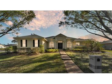 Single-story home with a classic design, landscaping, and walkway at 875 Hanover Way, Lakeland, FL 33813